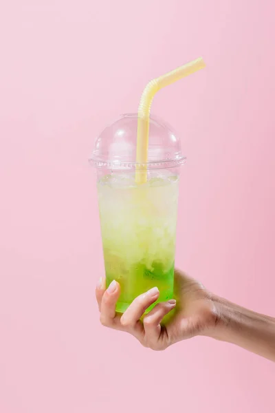 Cropped shot of woman holding plastic cup of mojito isolated on pink — Stock Photo