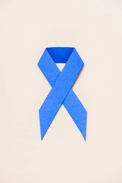 Flat lay with prostate cancer awareness blue ribbon on beige — Stock Photo