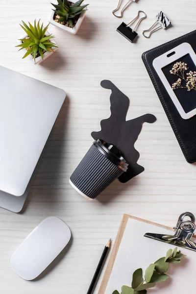 Top view of workplace with laptop, paper coffee cup, computer mouse and keyboard at table in office — Stock Photo