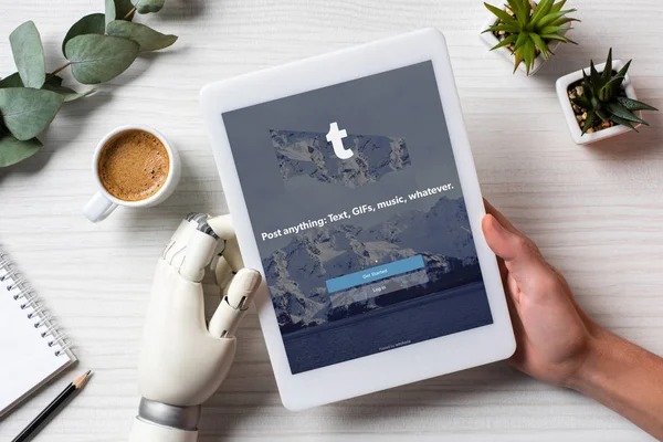 Кадроване зображення бізнесмен з протезування вручну, використовуючи цифровий планшет з квитки на екрані за столом з чашкою кави в офісі — стокове фото
