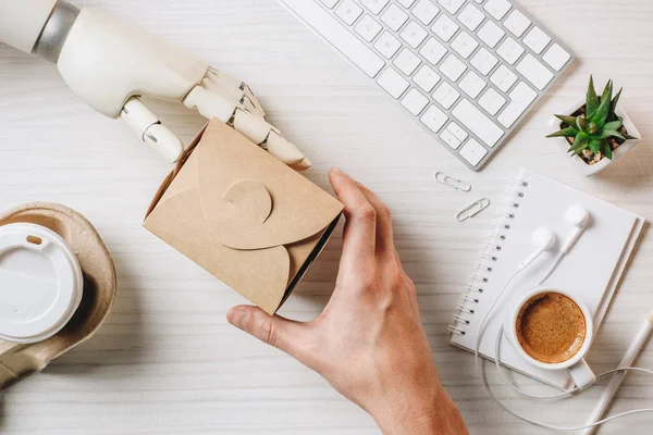 Imagem cortada de empresário com braço de prótese almoçando com wok e café à mesa no escritório — Fotografia de Stock