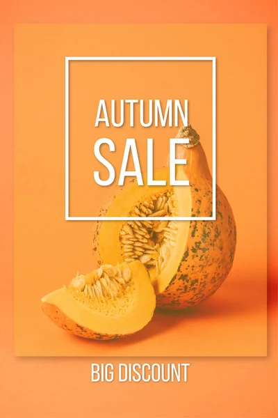 Vue rapprochée de citrouille crue coupée avec inscription de vente d'automne sur fond orange — Photo de stock