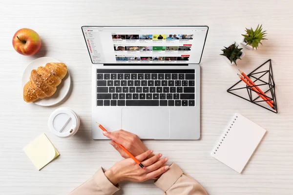 Plan recadré de mains féminines, ordinateur portable avec site youtube et déjeuner sur la table au bureau — Photo de stock