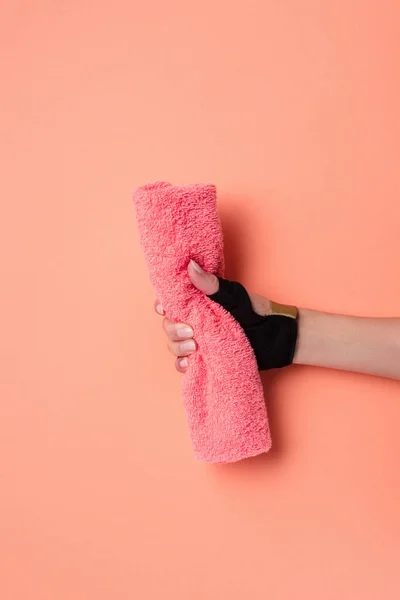 Vista recortada de la mano femenina con toalla sobre fondo beige - foto de stock