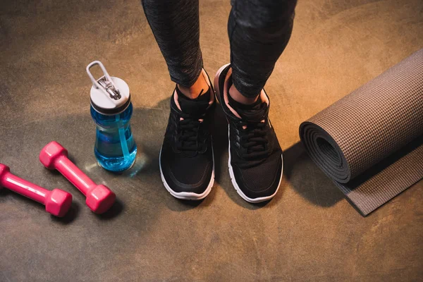 Cropped view of female legs with sports equipment — Stock Photo