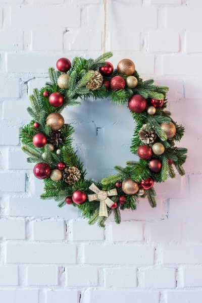 Christmas wreath hanging on white brick wall — Stock Photo