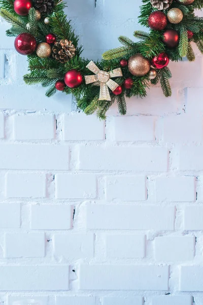 Primer plano de la corona de Navidad en el fondo de la pared de ladrillo blanco - foto de stock