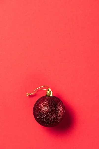 Верхний вид на красный блестящий декоративный рождественский бал на красном фоне — стоковое фото