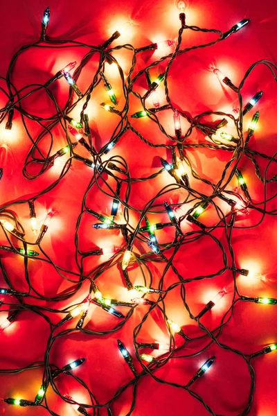 Shining colourful garlands on red  background — Stock Photo