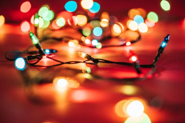 Verschwommen leuchtende bunte Girlanden als weihnachtlicher Hintergrund — Stockfoto