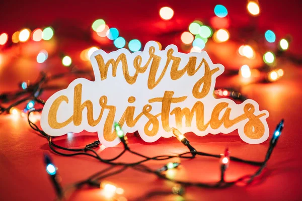Merry Christmas sign on the background of shining garlands — Stock Photo