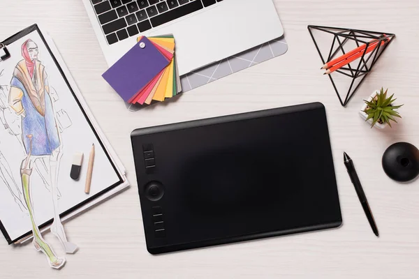 Office desk with laptop, sketches, graphics tablet and pen, flat lay — Stock Photo