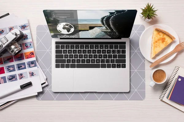 Office desk with laptop with booking website on screen, flat lay — Stock Photo
