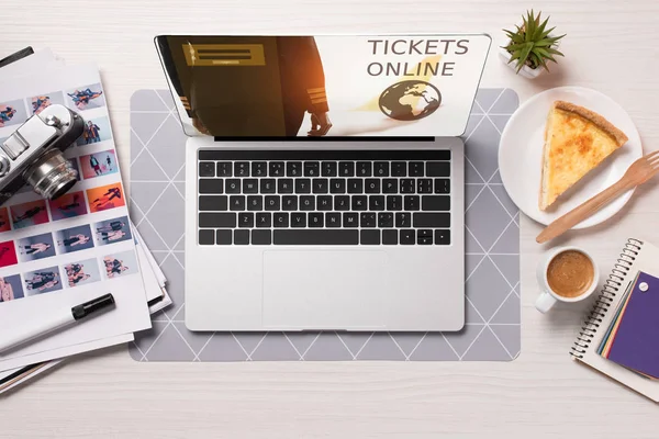 Office desk with laptop with tickets online website on screen, flat lay — Stock Photo