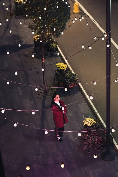 High angle view of attractive asian girl in burgundy kimono walking on street in evening, city of future concept — Stock Photo