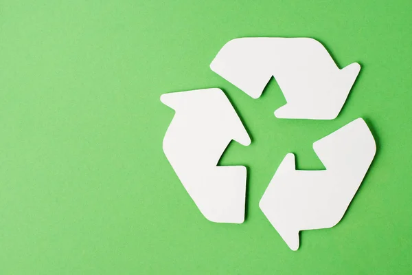 Top view of white recycle sign on green background — Stock Photo