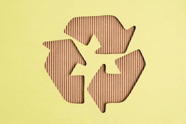 Top view of cardboard recycle sign on yellow background — Stock Photo