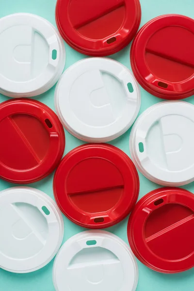 Top view of red and white disposable lids for drink arranged on blue background — Stock Photo