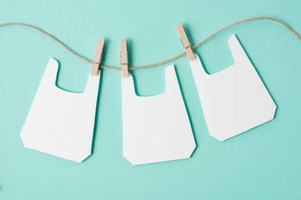 Models of packets hanging on rope on blue background — Stock Photo