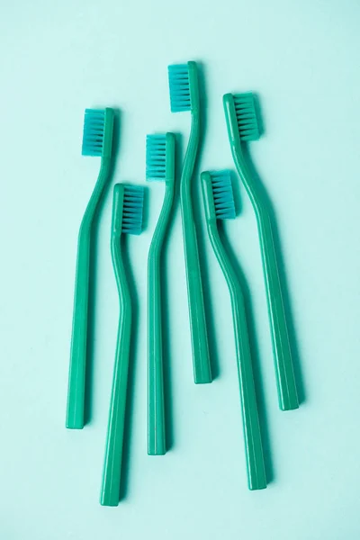 Top view of plastic turquoise toothbrushes arranged on blue background — Stock Photo