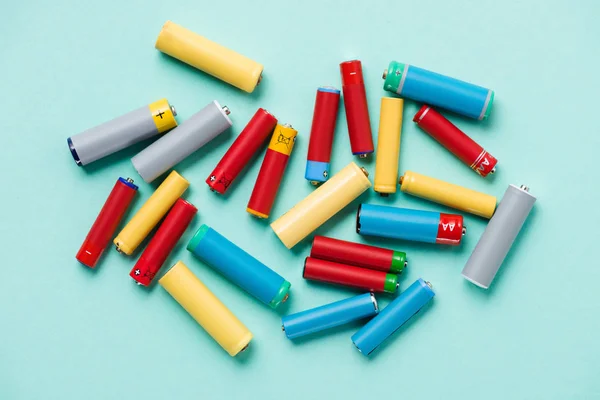 Vista superior de coloridas baterías dispersas sobre fondo azul — Stock Photo
