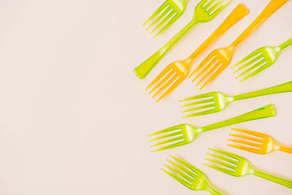 Vue de dessus des fourchettes en plastique coloré sur fond rose — Photo de stock