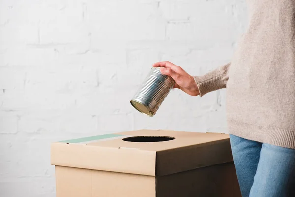 Partial view of woman throwing tin can in trash bin — Stock Photo