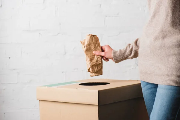 Partial view of woman throwing paper in trash bin — Stock Photo