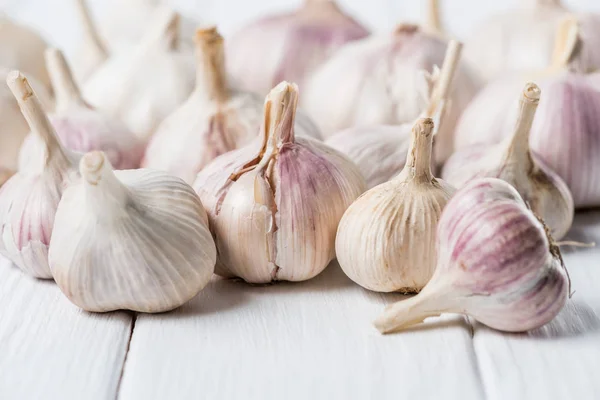 Bulbs of garlic on white rustic wood table — Stock Photo