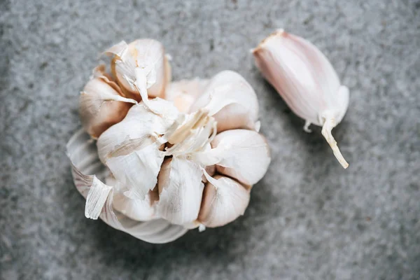 Top view of peeled ripe garlic bulb on grey background — Stock Photo