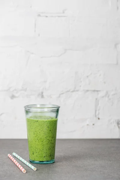 Smoothie bio vert mélangé en verre avec des pailles — Photo de stock