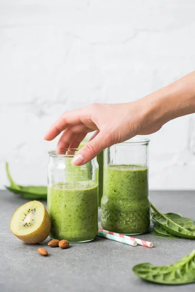 Female hand holding glass with green smoothie — Stock Photo