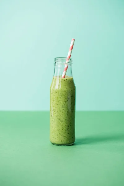 Green and healthy organic smoothie in glass bottle with straw — Stock Photo