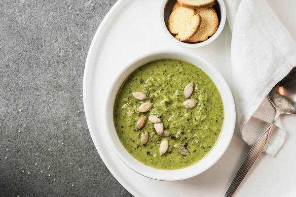 Vue de dessus de la soupe crémeuse fraîche et verte sur plateau blanc — Photo de stock