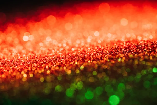 Glowing christmas texture with red and green blurred glitter — Stock Photo