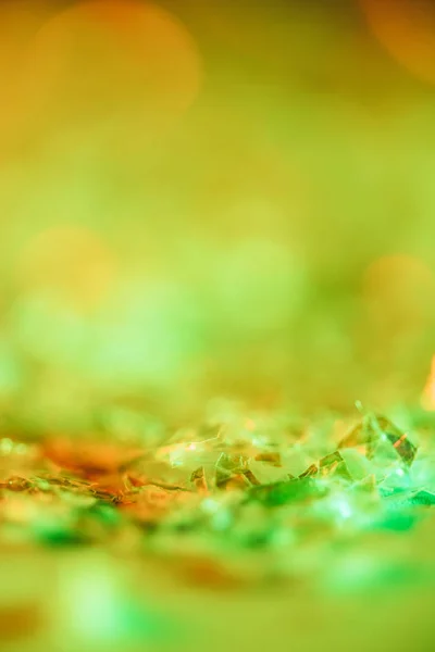 Abstrait fond brillant avec des paillettes orange et vert — Photo de stock