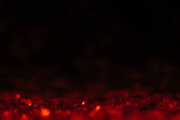 Red defocused glitter on black background with copy space — Stock Photo