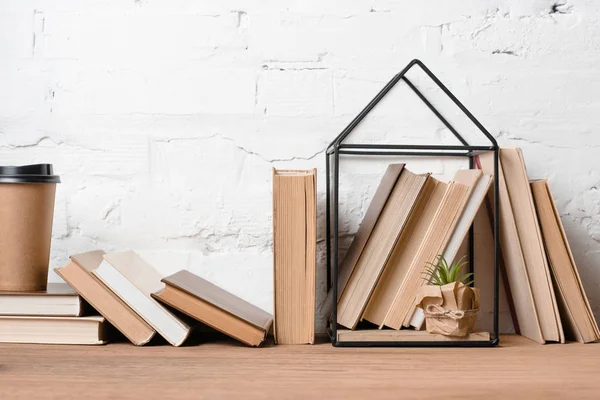 Bücher, Coffee to go und grüne Topfpflanze auf Holztisch — Stockfoto