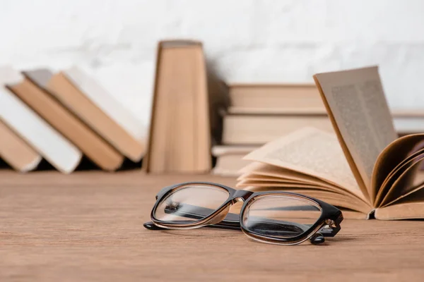 Vue rapprochée des lunettes et des livres sur table en bois — Photo de stock