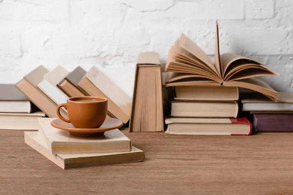 Libros y taza de café sobre mesa de madera - foto de stock