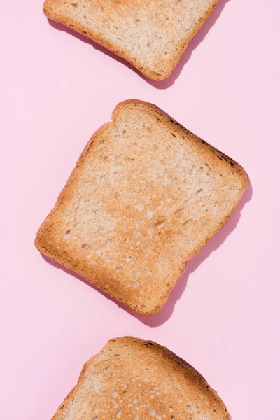 Top view of row of delicious toasts on pink tabletop — Stock Photo