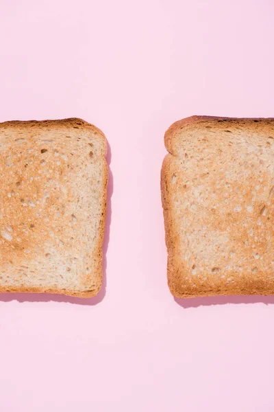 Top view of roasted toasts on pink surface — Stock Photo