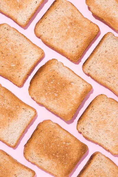 Vista superior del patrón de tostadas crujientes en la superficie rosa — Stock Photo