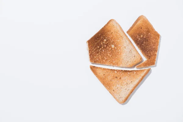 Vista superior de la forma del corazón hecha de pan tostado en la superficie blanca - foto de stock