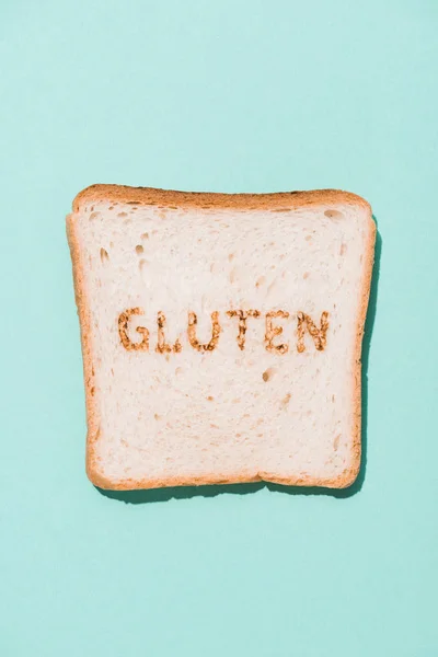 Vista dall'alto di fila di fetta di pane con segno di glutine sulla superficie blu — Foto stock
