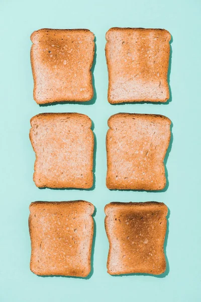 Draufsicht auf montierte knusprige Toasts auf blauer Oberfläche — Stockfoto