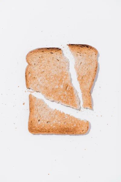 Vue de dessus du pain grillé déchiré sur la surface blanche — Photo de stock