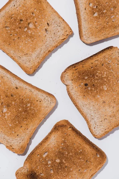 Blick von oben auf köstliche knusprige Toasts verschüttet auf weißer Oberfläche — Stockfoto