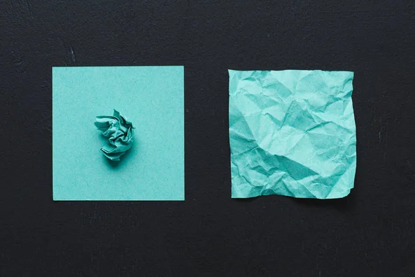 Top view of turquoise crumpled paper on black background, think different concept — Stock Photo