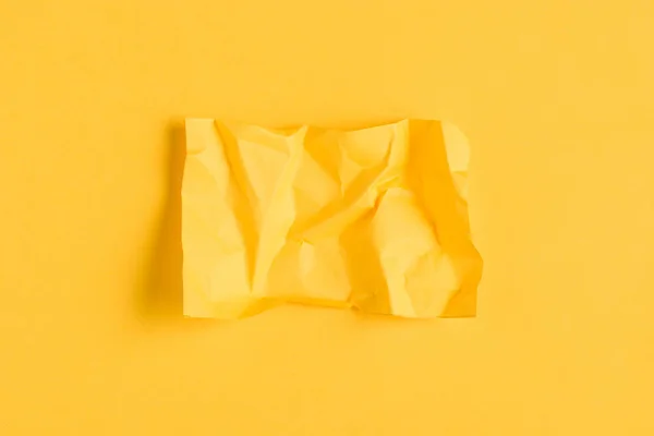 Crumpled paper on yellow background with copy space — Stock Photo